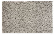 a gray rug with small black and white dots on the bottom, in front of a white background