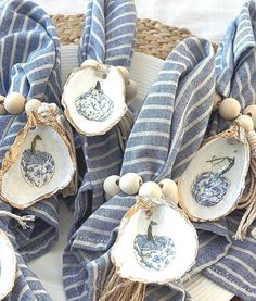 some blue and white dishes are on a plate with striped napkins, wood beads and tassels