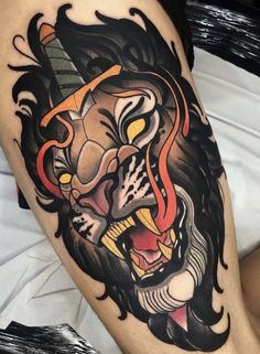 a lion tattoo on the thigh with flames coming out of its mouth and an eye