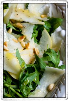 a white bowl filled with green vegetables and nuts