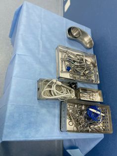 three pieces of silverware sitting on top of a blue box with scissors and other items in it