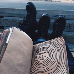 someone is sitting on a bench with their book