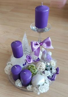 purple candles and white flowers in a glass bowl