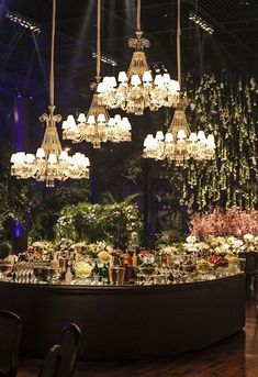 a table with chandeliers hanging from it's ceiling and flowers in vases