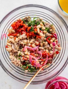 a glass bowl filled with beans, meat and veggies