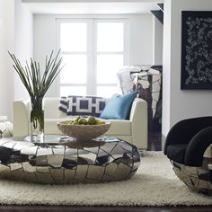 a living room filled with furniture and a plant in a vase on top of a coffee table