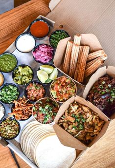 an open box filled with lots of different types of food on top of a wooden table