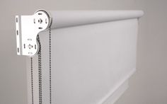 a white curtain with chains hanging from it's side and the bottom half closed