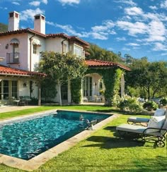 a large house with a pool in the front yard and lawn furniture on the other side