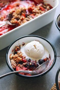 a bowl filled with fruit and ice cream next to another bowl full of desserts