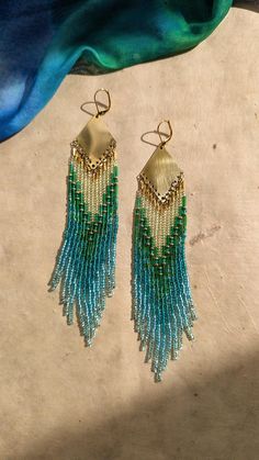 ♀ Bohemian seed beaded earrings handmade with glass satin beads, brass, agate stones, and nylon thread.. ♀ Drop Height: 6 in. ♀ Beads: Toho, Miyuki, Czech ♀ Ear Wire: 18k gold-plated brass ♀ Thread: Nylon ♀ Nickel Free Get 20% off when you shop from my website! link to earrings below! https://moonandmilk.com/products/hallie-aqua-green-seed-bead-earrings use code: ETSY20 Affordable Green Beaded Earrings For Beach, Multicolor Beaded Brass Earrings, Brass Jewelry With Tiny Beads In Dangle Shape, Festival Brass Jewelry With Tiny Beads, Festive Beaded Brass Earrings, Beaded Dangle Earrings In Brass, Gold Beaded Brass Earrings For Festivals, Multicolor Dangling Beaded Brass Earrings, Festive Brass Beaded Earrings