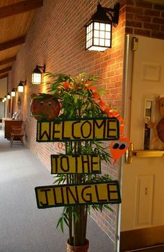 a welcome to the thing sign in front of a brick wall with potted plants