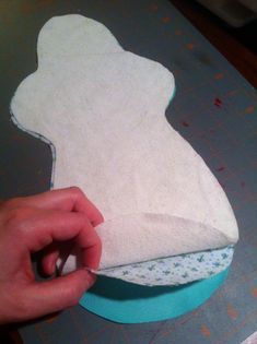 someone is cutting out the shape of a baby's bib