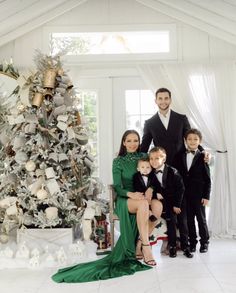 a family posing for a photo in front of a christmas tree