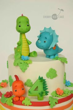 a birthday cake with two dinosaurs on top