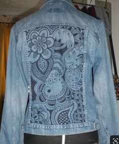 a denim jacket with an intricate design on the back