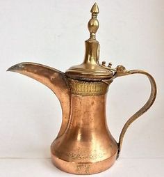 an antique brass coffee pot with a handle