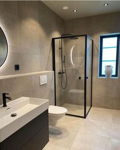 a bathroom with a sink, toilet and shower stall in the middle of the room