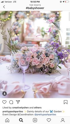 a table with flowers and wine glasses on it, surrounded by pink ribboned napkins