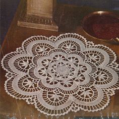 an image of a doily on a table next to a pot holder and bowl