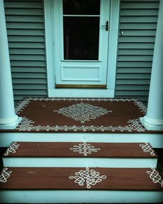 two brown steps with white designs painted on them in front of a door and window