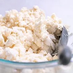 a glass bowl filled with cottage cheese and a spoon