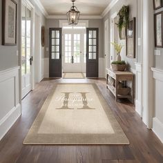 a hallway with white walls and wood flooring has a large welcome mat on the wooden floor