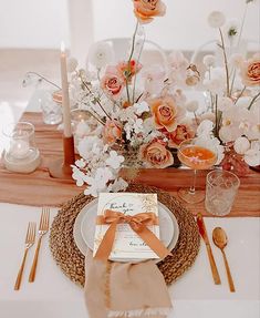 the table is set with flowers, candles and place settings for an elegant dinner party