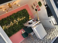 a room with pink walls and black and white flooring, plants on the wall