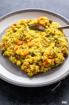 a white plate topped with rice and vegetables