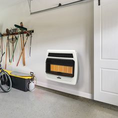 a bike parked next to a wall mounted heater and some skis hanging on the wall