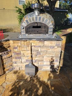 an outdoor pizza oven sitting on top of a stone patio