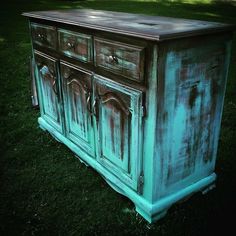 an old dresser is sitting in the grass with green paint on it's doors