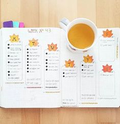 a cup of coffee sitting on top of an open planner