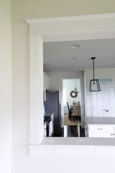 an open kitchen and dining room with white cabinets