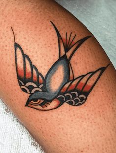 a close up of a bird tattoo on a person's leg