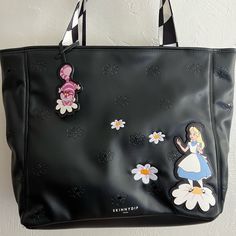 Large Faux Leather Black Tote Imprinted Flowers Hanging Cheshire Cat Tag Large Carryall Approx Measurement: 16"W X 13"H X 13"D Snap Closure Interior: Fabric Lined 1 Zip Pocket & 1 Slip Pocket Cute Black Bags For Spring, Cute Black Bag For Spring, Black Shoulder Bag With Cat Print For Daily Use, Alice Bag Punk, Alice In Wonderland Purse, Black Rectangular Bag With Cat Print, Rectangular Black Cat Print Shoulder Bag, Skinnydip London, London Bags