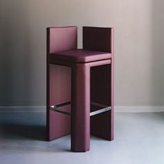 a purple chair sitting on top of a white floor next to a wall with a window