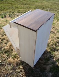 an old refrigerator sitting in the middle of a field