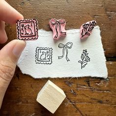 someone is stamping some stamps on top of a piece of white paper with pink bows