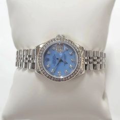 Women's Rolex 26mm DateJust Stainless Steel Watch with Powder Blue Diamond Dial and Diamond Bezel. Pre-Owned Brand: Rolex. Crystal: Sapphire. Dial: Diamond Dial. Gender: Women's. Dial Color: Powder Blue. Movement: Self-Winding. Case Dimensions: 26mm. Metal Type: Stainless Steel. Bezel: Custom Diamond Bezel. Bracelet / Strap: Original Jubilee. Box / Certificate: Rolex Box / Certificate of Authenticity. Service Warranty: One (1) Year Limited Service Warranty. NOTE: This beautiful Rolex watch inclu Blue Diamond Watch With Round Dial, Elegant Blue Watch Accessories With Diamond Hour Markers, Blue Diamond Luxury Watch For Formal Occasions, Luxury Blue Diamond Watch For Formal Occasions, Blue Diamond Watch With Diamond Hour Markers For Anniversary, Blue Luxury Diamond Watch For Formal Occasions, Blue Diamond Watch For Anniversary, Formal Jubilee Bracelet Watch Accessory, Blue Diamond Watch With Diamond Hour Markers