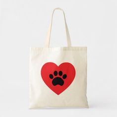 a red heart with a black paw print on it and a white tote bag