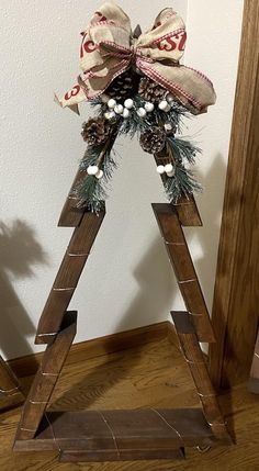 a wooden christmas tree with pine cones and bows