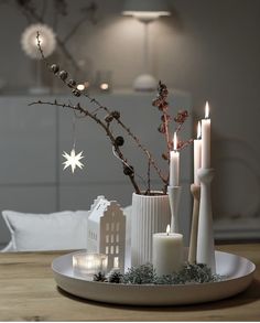 a white plate topped with candles on top of a wooden table