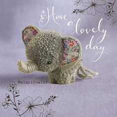 there is a small stuffed elephant with flowers on it's head and the words have a lovely day written in cursive writing