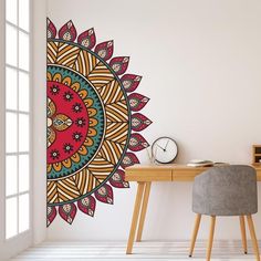 a room with a desk, chair and large wall decal on the wall that has a colorful flower design