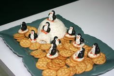 a plate with crackers and penguins on top of it, surrounded by crackers