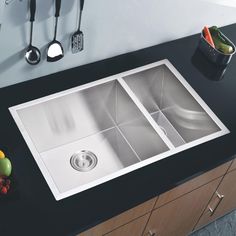 a kitchen sink sitting on top of a counter next to utensils and spoons