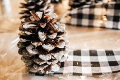 a pine cone sitting on top of a checkered table cloth next to other christmas decorations