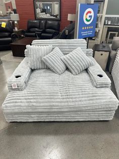 a bed that is on display at a furniture store in front of some couches and chairs